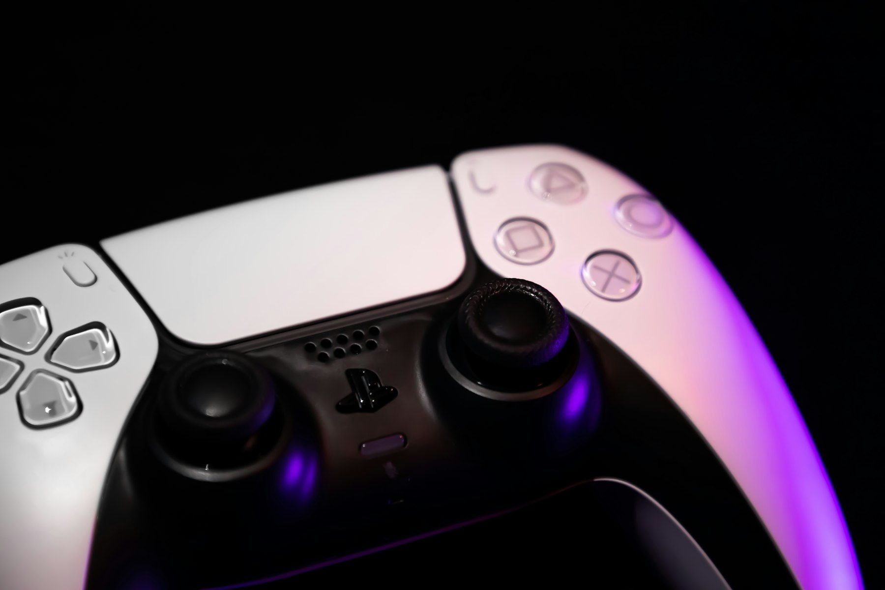 A video game controller resting against a dark background.