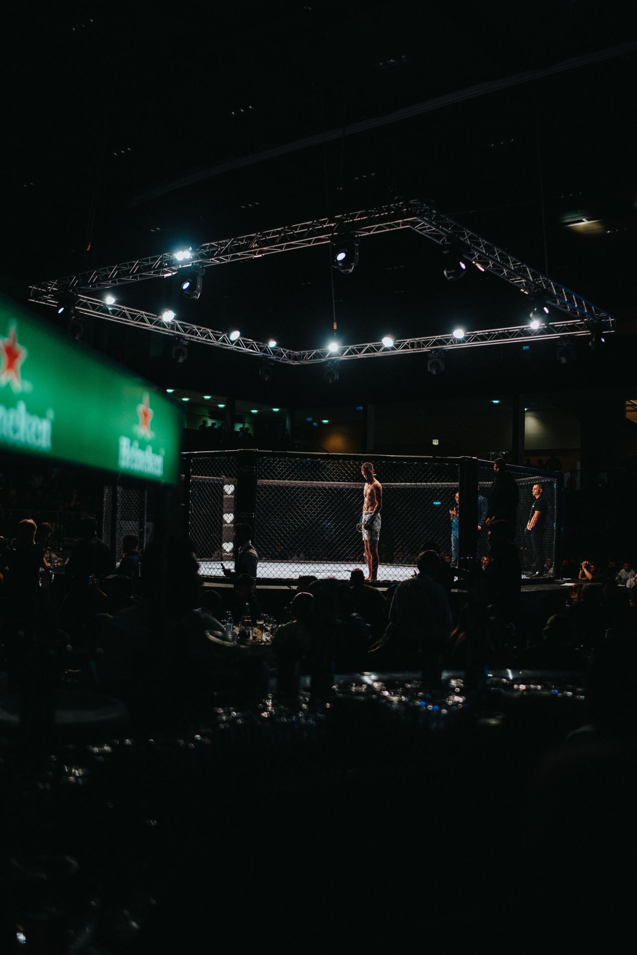 An illuminated octagon cage set up for a mixed martial arts event.